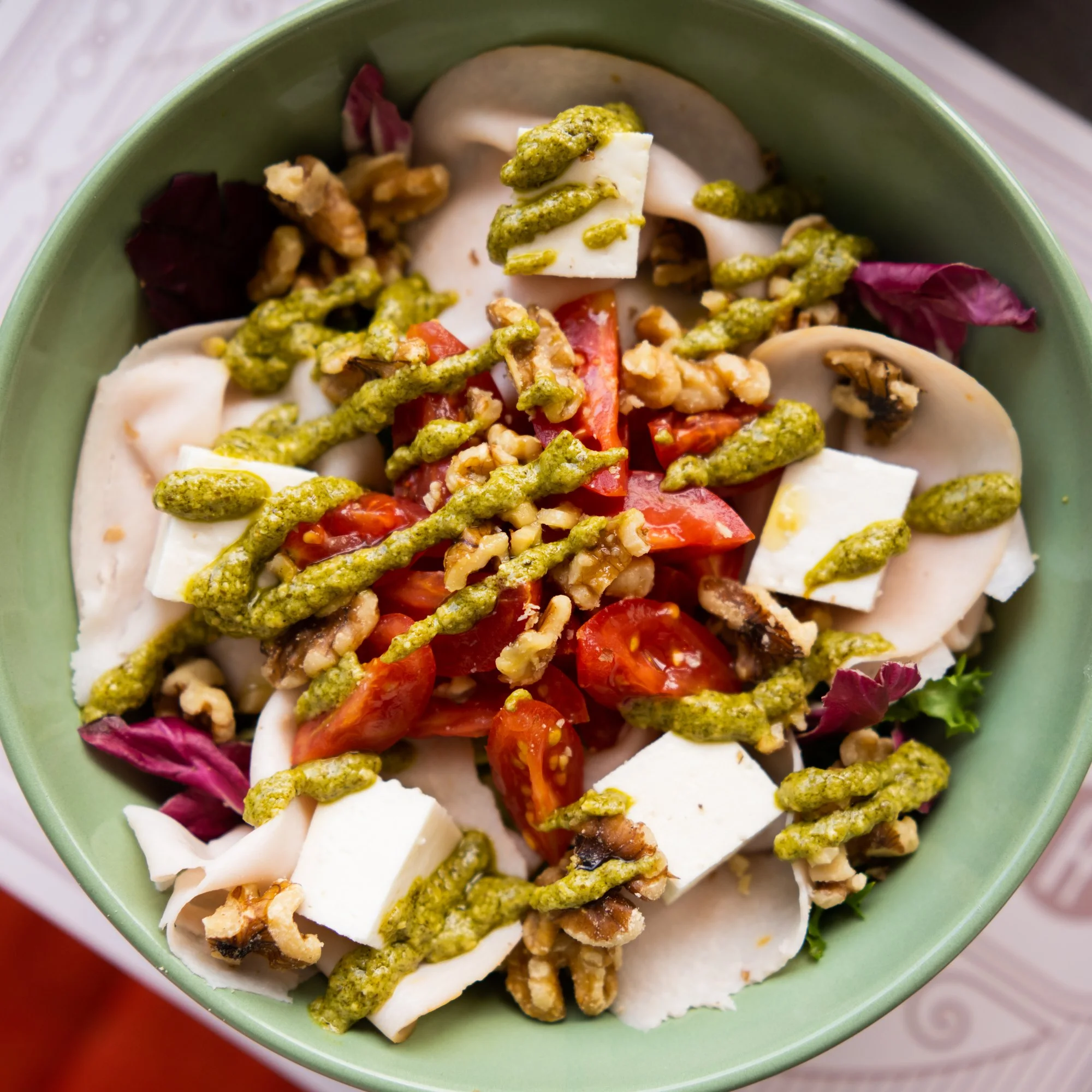 Insalata con pesto, noci, pomodorini e formaggio fresco